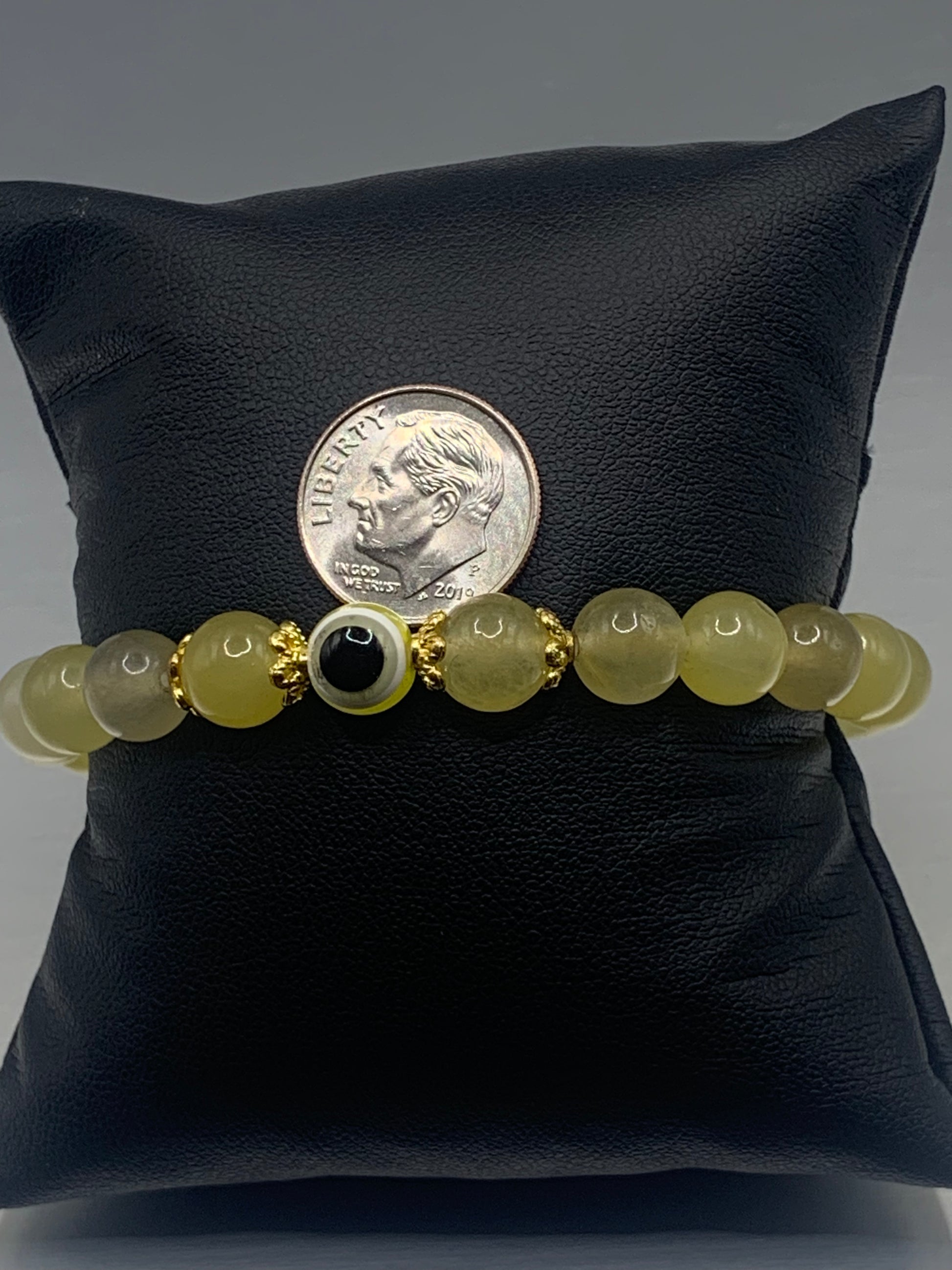 This bracelet features yellow agate beads and a colorful evil eye resin bead with gold flower caps. These are 8mm beads, made with elastic string to stretch onto the wrist and is approximately 17 cm or 6.7 inches.

These are natural semi-precious stones/crystals. Even if they are dyed, the base material is still natural and imperfections are common making them unique.