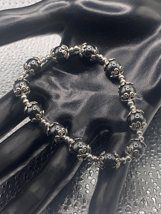 This bracelet contains hematite beads that are surrounded by bead caps and spacer beads