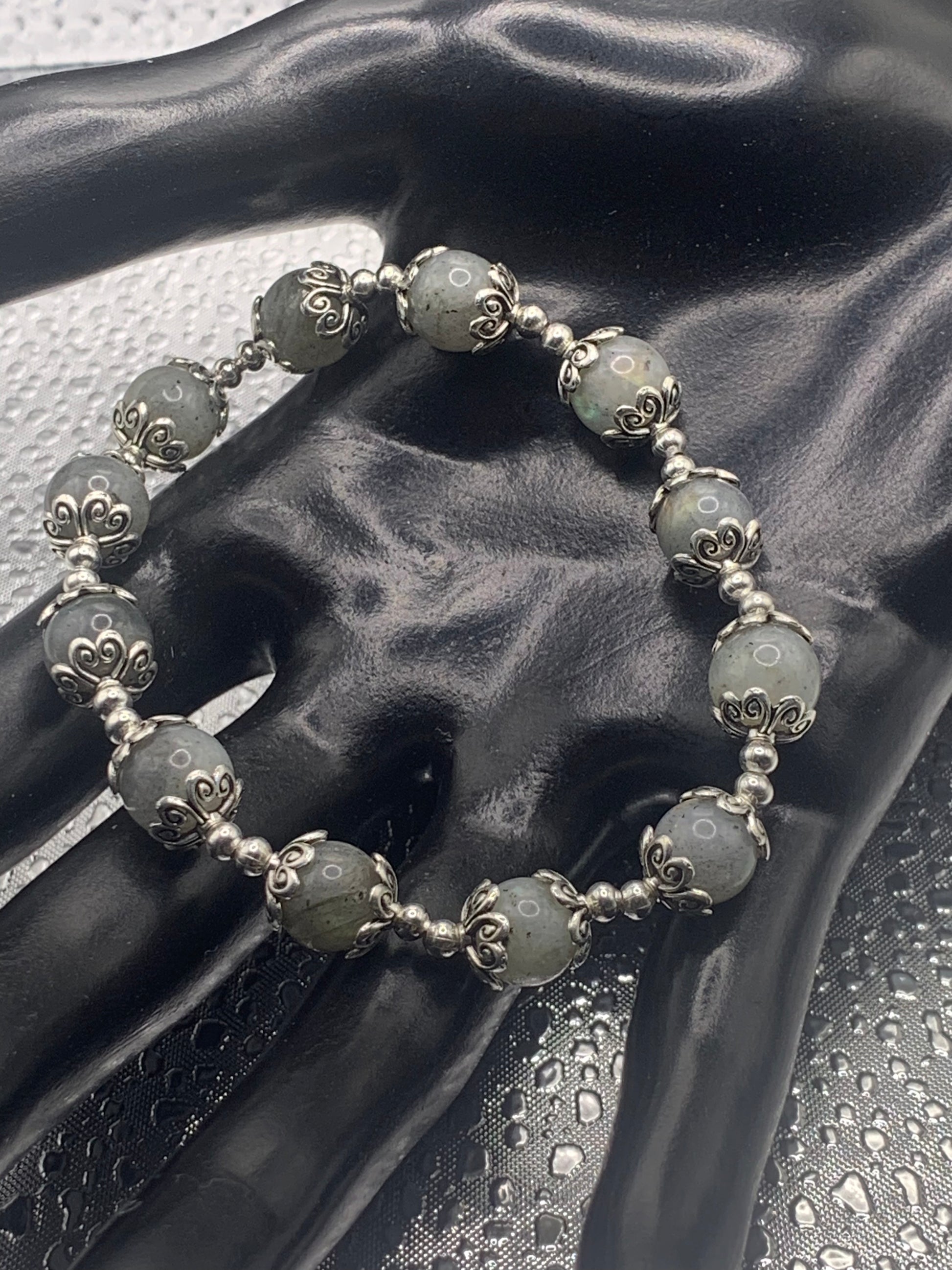 This bracelet contains labradorite beads that are surrounded by bead caps and spacer beads