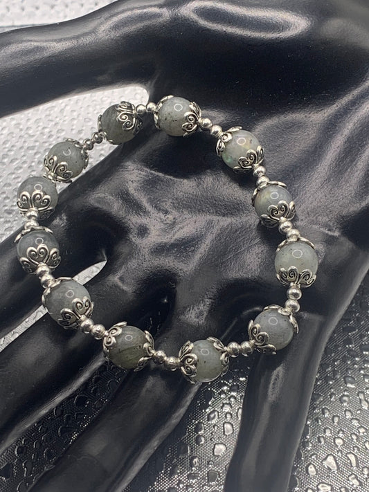 This bracelet contains labradorite beads that are surrounded by bead caps and spacer beads