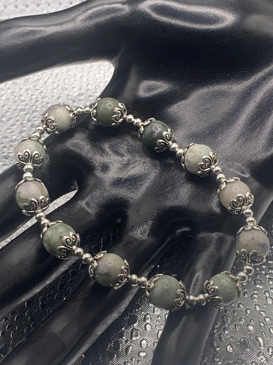 This bracelet contains lucky jade beads that are surrounded by bead caps and spacer beads