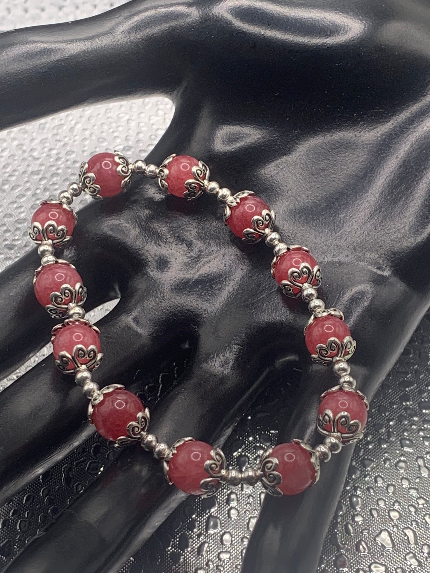 This bracelet contains pink chalcedony beads that are surrounded by bead caps and spacer beads