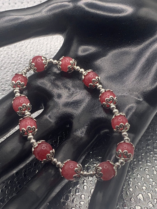 This bracelet contains pink chalcedony beads that are surrounded by bead caps and spacer beads