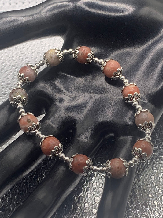This bracelet contains pink lepidolite beads that are surrounded by bead caps and spacer beads