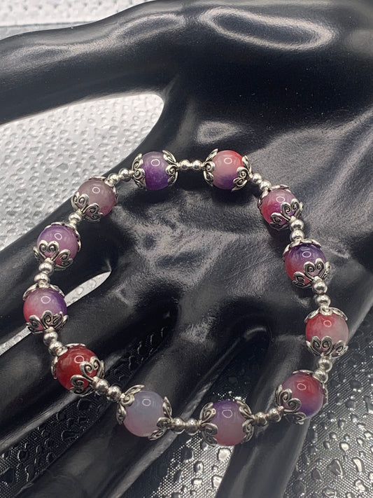 This bracelet contains purple pink agate beads that are surrounded by bead caps and spacer beads