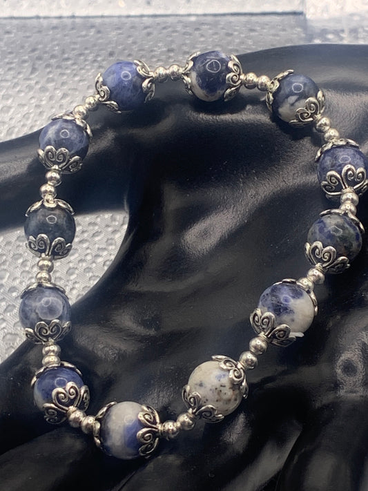This bracelet contains sodalite beads that are surrounded by bead caps and spacer beads