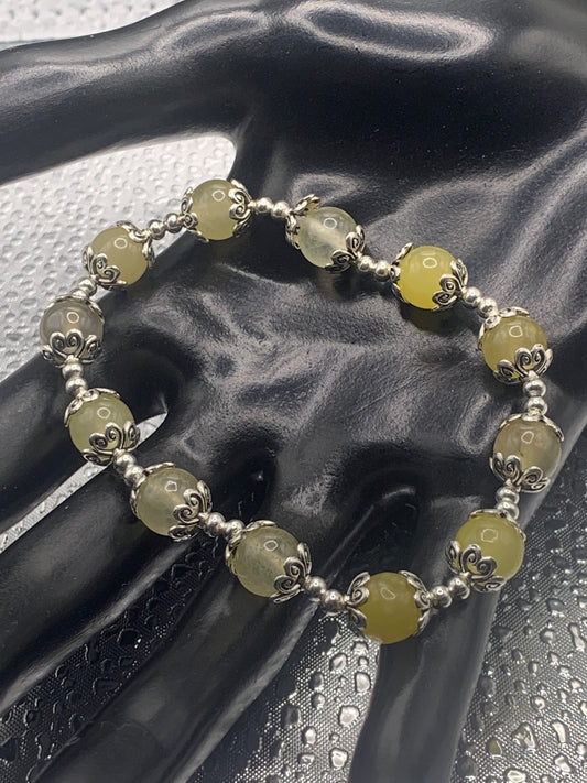 This bracelet contains yellow agate beads that are surrounded by bead caps and spacer beads