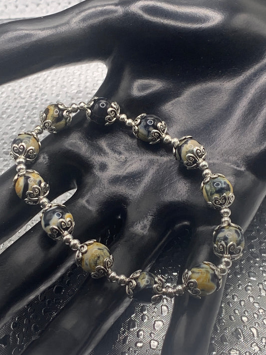 This bracelet contains yellow orca agate beads that are surrounded by bead caps and spacer beads